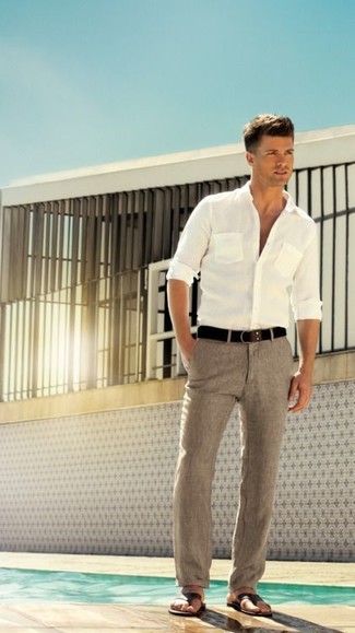 Белая рубашка с длинным рукавом и серые льняные классические брюки помогут создать эффектный образ. Этот образ идеально дополнят коричневые сандалии.