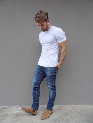 Поклонникам стиля casual придется по вкусу сочетание белой футболки с круглым вырезом и синих джинсов. Чтобы немного разнообразить образ и сделать его элегантнее, можно надеть бежевые ботинки челси.