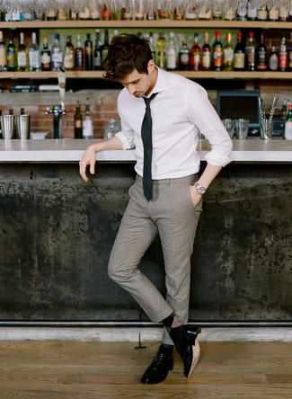 белая классическая рубашка в паре с серыми шерстяными классическими брюками позволит создать стильный классический образ. Черные туфли станут отличным завершением образа.