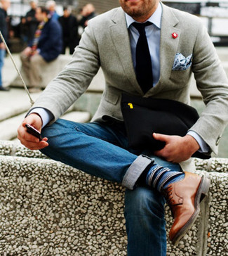 Приверженцам стиля business casual должно понравиться сочетание серого шерстяного пиджака и синих джинсов. Разнообразить образ и добавить в него немного классики помогут светло-коричневые кожаные туфли дерби.