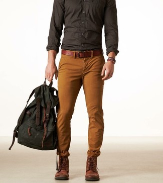 Приверженцам стиля casual должно понравиться сочетание темно-серой рубашки с длинным рукавом и табачных брюк чинос. Темно-коричневые кожаные ботинки добавят образу изысканности.
