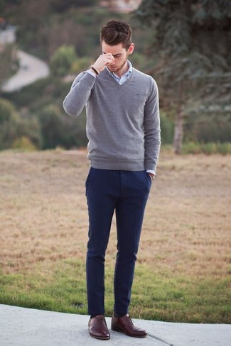 Серый свитер с v-образным вырезом и темно-синие брюки чинос — прекрасный выбор, если ты хочешь создать непринужденный, но в то же время стильный образ. И почему бы не добавить в этот образ элегантности с помощью коричневых кожаных оксфордов?