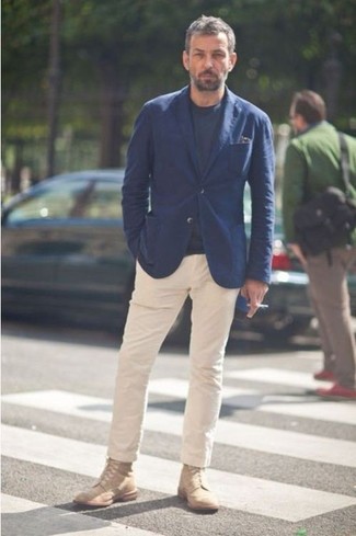 Сочетание темно-синего пиджака и бежевых брюк чинос подойдет для свидания или мероприятия с дресс-кодом dressy casual. Светло-коричневые ботинки — прекрасный вариант, чтобы завершить образ.