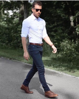 Белая рубашка с длинным рукавом отлично сочетается с темно-синими джинсами. Коричневые кожаные повседневные ботинки добавят образу эффектности.