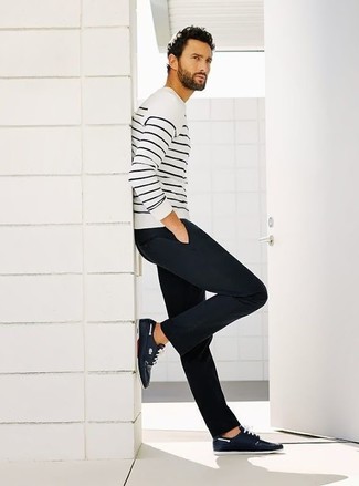 Бело-черный свитер с круглым вырезом в горизонтальную полоску и темно-синие брюки чинос — выгодные инвестиции в твой гардероб. И почему бы не разбавить образ с помощью темно-синих кед?