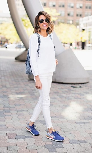 Белый свитер с круглым вырезом и белые рваные джинсы скинни будут гармонично смотреться в модном гардеробе самых привередливых красавиц. Очень стильно здесь будут смотреться синие кеды.