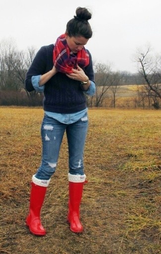Темно-синий вязаный свитер и синие рваные джинсы скинни — хороший вариант для прогулки с друзьями или похода по магазинам. И почему бы не добавить в этот образ немного непринужденности с помощью красных резиновых сапог?