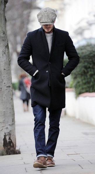Черное длинное пальто и темно-синие джинсы — необходимые вещи в классическом мужском гардеробе. Что касается обуви, коричневые повседневные ботинки станут отличным выбором.