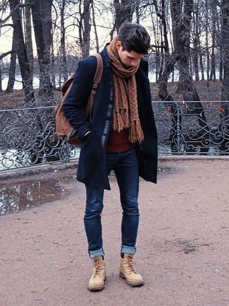 Темно-синее длинное пальто и темно-синие зауженные джинсы позволят создать гармоничный деловой образ. Что касается обуви, неплохо дополнят образ бежевые повседневные ботинки.