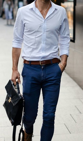 Голубая классическая рубашка и темно-синие зауженные джинсы — необходимые вещи в гардеробе мужчины с чувством стиля. Очень гармонично здесь будут смотреться коричневые кожаные ботинки.