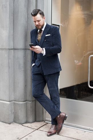 Темно-синий костюм-тройка и бело-коричневая классическая рубашка в вертикальную полоску помогут создать эффектный образ. Что касается обуви, неплохо дополнят образ темно-коричневые классические ботинки.