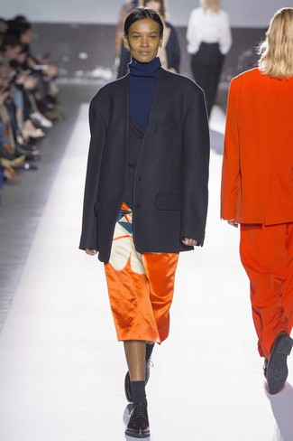Черный пиджак и оранжевая юбка-миди с принтом — беспроигрышный вариант для прогулки с друзьями или похода по магазинам. Очень стильно здесь будут смотреться оксфорды.