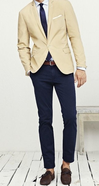 Бежевый пиджак и темно-синие брюки чинос — необходимые вещи в классическом мужском гардеробе. Этот образ идеально дополнят темно-коричневые замшевые мокасины.