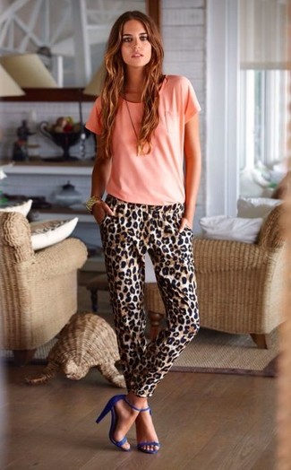 Розовая футболка с круглым вырезом и коричневые брюки-галифе с леопардовым принтом — необходимые вещи в арсенале стильной современной женщины. Выбирая обувь, можно немного побаловаться и завершить образ синими босоножками.