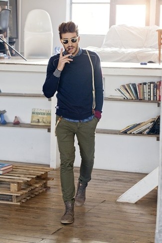 Приверженцам стиля casual должно понравиться сочетание темно-синего свитера с круглым вырезом и оливковых брюк чинос. Коричневые кожаные ботинки добавят образу эффектности.