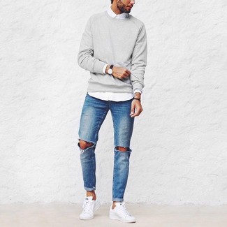 Серый свитер с круглым вырезом и синие рваные джинсы — выгодные инвестиции в твой гардероб. И почему бы не разбавить образ с помощью белой обуви?
