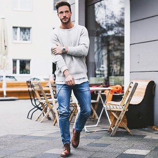 Серый свитер с круглым вырезом и синие зауженные джинсы — необходимые вещи в гардеробе любителей стиля casual. Чтобы немного разнообразить образ и сделать его элегантнее, можно надеть коричневые ботинки броги.