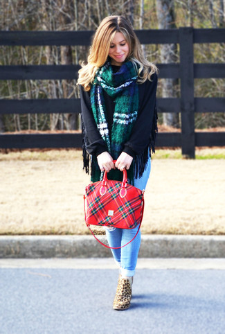 Черный свободный свитер и голубые рваные джинсы скинни — стильный выбор девушек, которые постоянно в движении. Чтобы образ не получился слишком строгим, можно надеть светло-коричневые ботинки с леопардовым принтом.