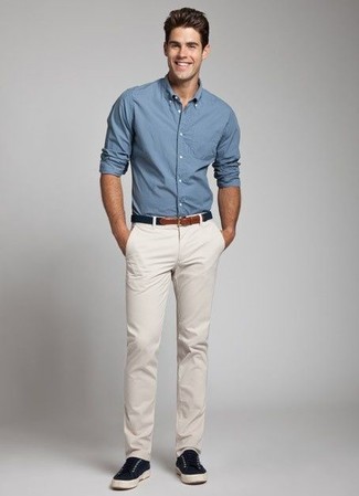 Синяя рубашка с длинным рукавом и бежевые брюки чинос — великолепный вариант простого, но стильного лука. Темно-синие плимсоллы станут великолепным дополнением к твоему образу.