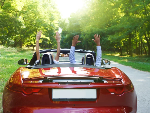 Бесплатно Счастливая пара, вождение в Красный ретро автомобиль аплодисменты радостное с — стоковое фото