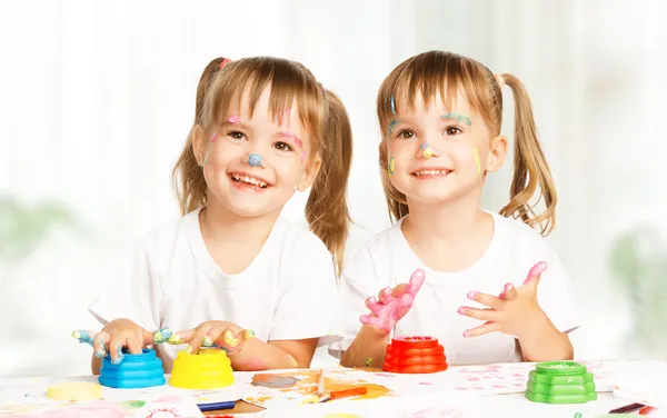 Счастливых детей близнецов рисует красками, пачкаются — стоковое фото