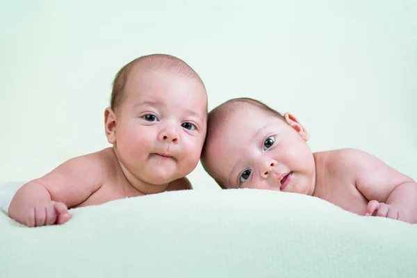 Смешные новорожденных близнецов, лежа на животе — стоковое фото