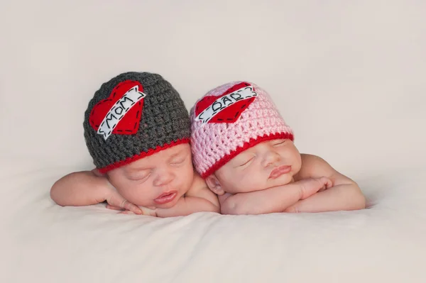 Новорожденных близнецов в любви мамы и папы шляпы — стоковое фото
