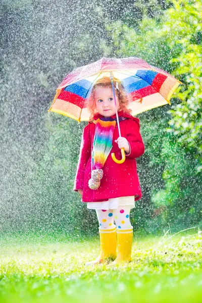 Маленькая девочка, играя в дождь — стоковое фото