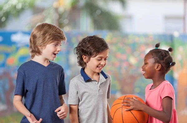 Дети, играть в баскетбол в школе — стоковое фото