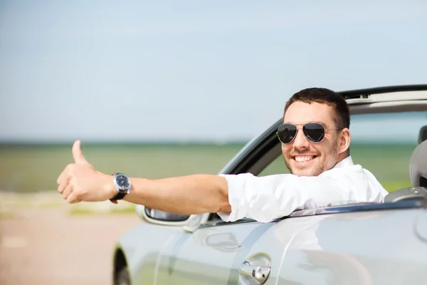 Счастливый человек за рулем автомобиля и показывая большой палец вверх — стоковое фото