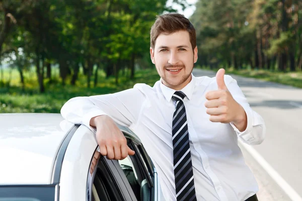 Человек с бородой листать вверх рядом автомобилей — стоковое фото