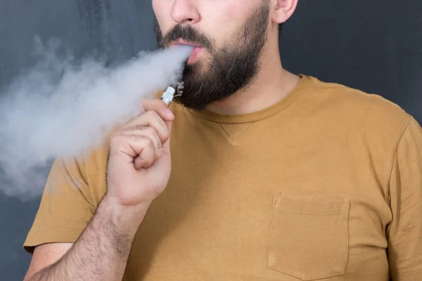Человек, курить электронную сигарету — стоковое фото