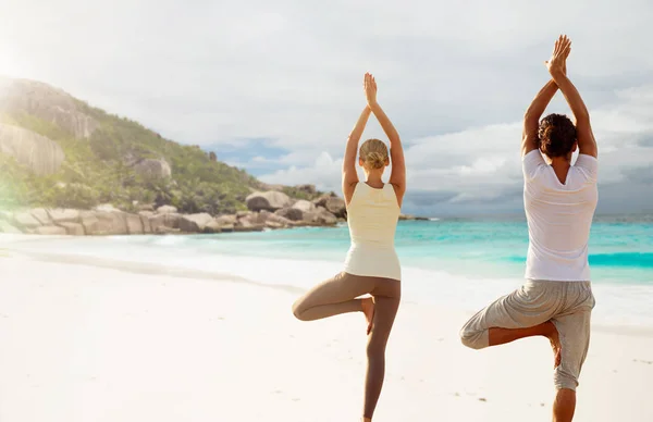 Молодая женщина, делая упражнения йоги на пляже — стоковое фото