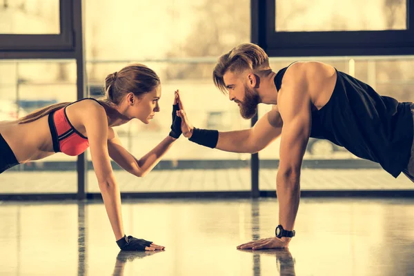Мужчина и женщина делают упражнения на доске — стоковое фото