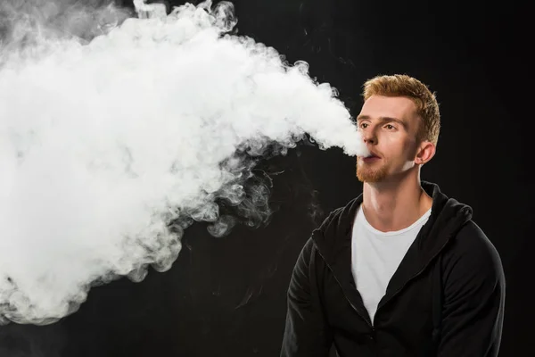 Молодой Бородатый Человек Выдыхая Дым Электронных Сигарет Окруженный Облака Пара — стоковое фото