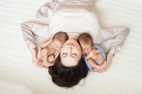 Мать, лежа с новорожденным девочка и мальчик — стоковое фото