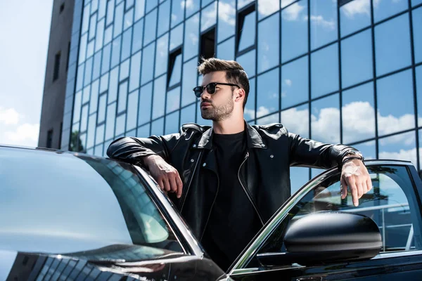 Young Stylish Man Leather Jacket Sunglasses Looking Away Car Street — стоковое фото