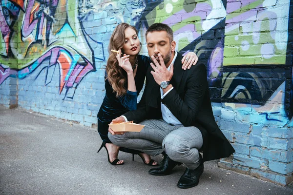 Couple Fashionable Outfit French Fries Sitting Wall Graffiti Street — стоковое фото