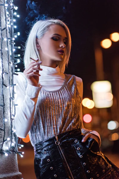 Beautiful Young Woman Smoking Street Night While Leaning Wall White — стоковое фото