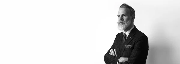Портрет бородатого уверен бизнесмен, носить модный костюм над пустой белый фон. Копировать вставить текст пространства. Широкий. Черный и белый — стоковое фото