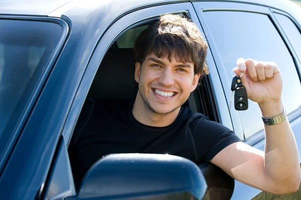 Счастливый человек, показывающий ключи в автомобиле — стоковое фото