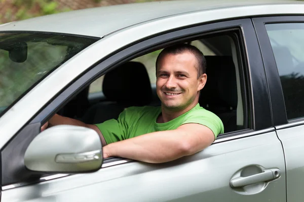 Счастливый молодой человек с новым автомобилем — стоковое фото