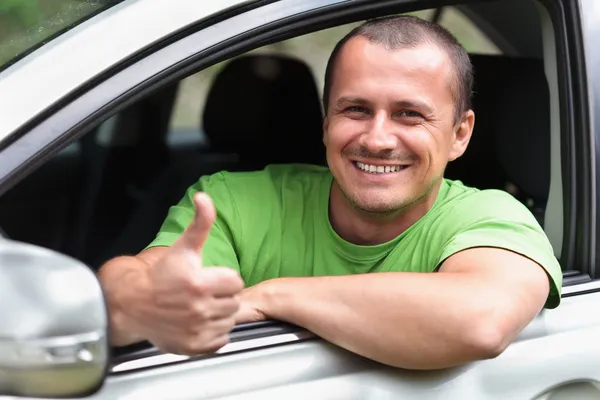 Счастливый молодой человек с новым автомобилем — стоковое фото