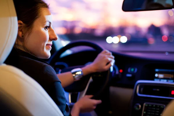 Женщина вождение его современный автомобиль на ночь в городе — стоковое фото