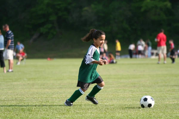 Молодая девушка, игра в футбол — стоковое фото