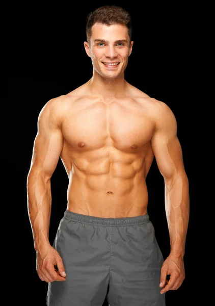 Портрет мышечной спортивный человек, стоящий на черном — стоковое фото