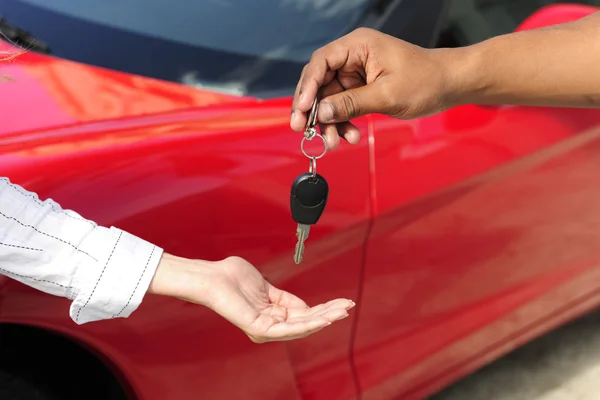 Женщина, получающая ключи от машины от продавца — стоковое фото